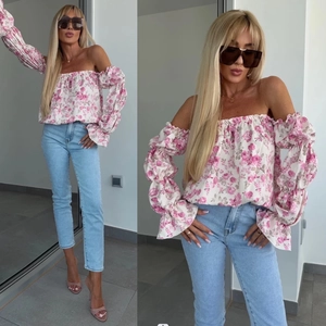 Camicetta a fiori rosa con spalle scoperte abbinata a jeans denim blu slim alla moda