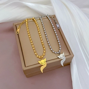 Titanium steel beaded fox charm bracelets in gold and silver finish on a jewelry box