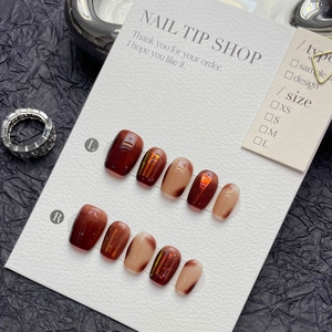 Handmade press-on nails in amber and dark red marble finish with gold foil accents