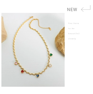 Detailed shot of golden rope chain necklace with five multi-colored heart zircon pendants