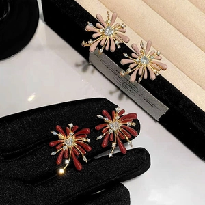 Detailed close-up of red and pink enamel firework earrings with zircon inlay