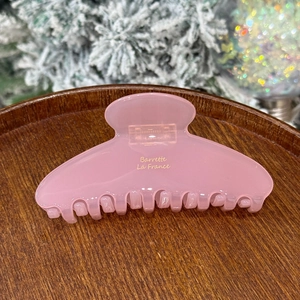 Detailed view of pink acetate hair claw clip with gold Barrette La France lettering