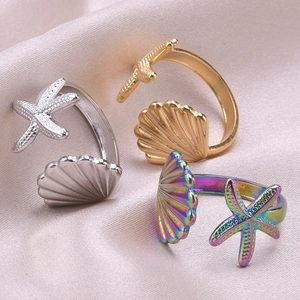 Detail of adjustable starfish and seashell rings in gold, silver, and rainbow finishes