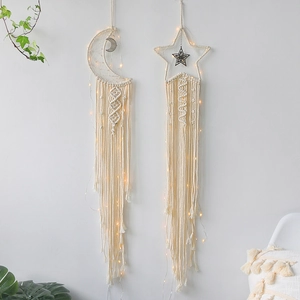 Handmade cotton woven star and moon dreamcatchers with LED lights on a white wall