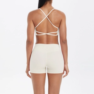 Détail de la brassière de yoga dos croisé et du short en tissu blanc crème extensible