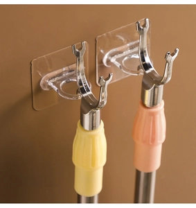 Detail of self-adhesive round curtain rod holders on a wall holding laundry poles