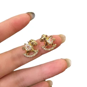Gold plated rocking horse stud earrings with teardrop cubic zirconia and small crystals