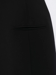Detail shot of a black off-shoulder dress featuring a welt pocket and fine woven fabric