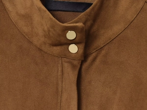Gros plan du col de chemise en daim marron avec boutons dorés de haute qualité