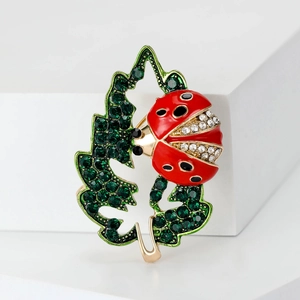 Sparkling ladybug and green leaf brooch with red crystals and gold-tone plating