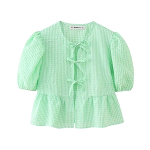 Nahaufnahme der grünen Gingham-Bluse mit Puffärmeln, Schleifen und Rüschensaum