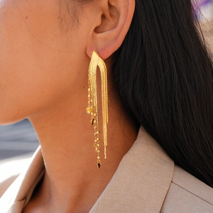 Détail de boucles d'oreilles à franges longues en plaqué or 18 carats sur un mannequin