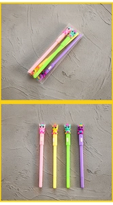 Detailed set of four colorful unicorn pens in a transparent box on a gray background