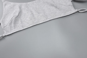 Detailed close-up of light gray ribbed knit fabric texture and high-quality edge stitching