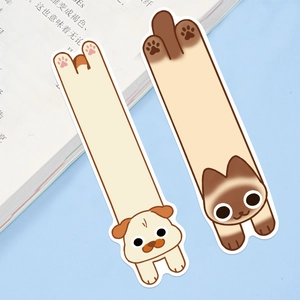 Detail of cute pug and Siamese cat paper bookmarks tucked inside an open book