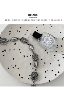 Macro detail of vintage silver waist chain with embossed texture on a ceramic plate