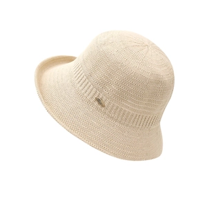 Beige hollow knit bucket hat for women with elegant metal logo and rolled edge design