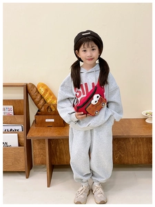 Girl wearing cute red car-shaped cartoon waist bag with waffle pattern in cozy setting