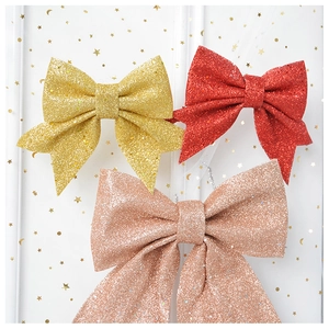 Detail of glitter bow ornaments in red, gold, and rose gold for Christmas tree decoration
