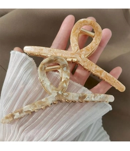Detail of elegant acetate hair claws with marble texture and golden metal spring