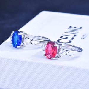 Detailed close-up of oval sapphire and ruby rings with silver-tone hollow bands