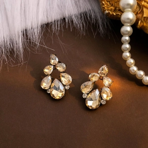 Macro shot of teardrop amber crystal earrings with vintage bronze floral settings