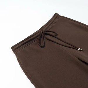 Détail de la taille élastique avec cordon et embouts métalliques sur pantalon évasé marron