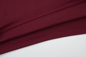 Detailed close-up of dark red knitted fabric with professional double-needle stitching