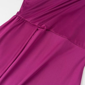 Détail de la couture à la taille et du tissu plissé magenta sur cette robe élégante