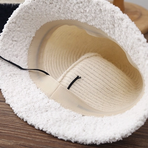 Chapeau bob en peluche blanche avec cordon de réglage interne sur support bois