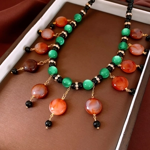 Detail of vintage beaded necklace with colorful stones and tassels on dark background