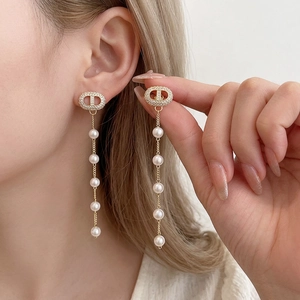Elegant gold earrings with sparkling CD letter studs and long hanging pearl tassels