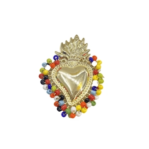 Macro detail of handmade golden sacred heart pendant with colorful seed beads
