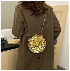Close-up of golden rose-shaped metal chain bag with layered petal texture on a model