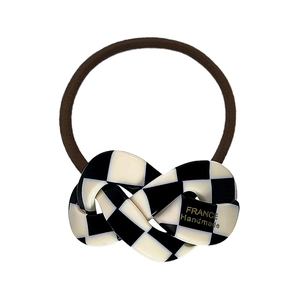 Elastic acetate hair tie featuring a black and white checkerboard pattern on white background