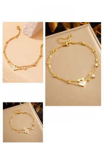 Detail of gold double-layered anklet featuring heart charms and tree of life pendants