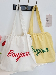 Canvas drawstring tote bag with French Bonjour lettering in red and green colors