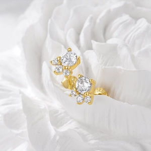 Macro shot of 925 silver gold-plated stud earrings with flower zircon inlay details