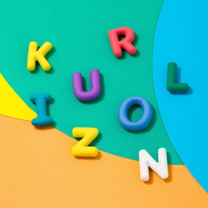 Close-up of vibrant 3D colorful alphabet charms in red yellow and blue on block background