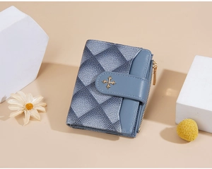 Detail of blue-grey quilted wallet with golden cross clasp and metallic zipper