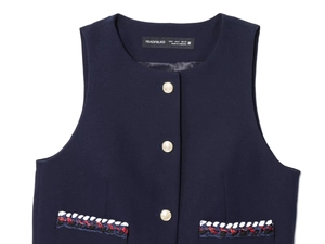 Détail du gilet bleu marine avec bordure tissée décorative et boutons dorés élégants