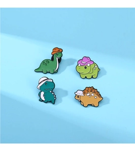 Close-up of four cute cartoon dinosaur enamel pins on a light blue background