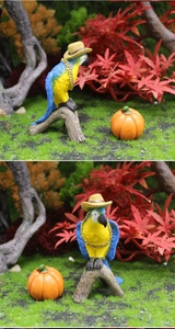 Close-up of resin parrot and pumpkin miniatures in a forest garden landscape decoration