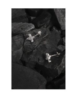 Detail of S925 sterling silver cross studs with cubic zirconia on black texture