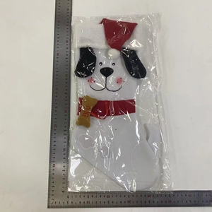 Detailed view of a white plush dog Christmas stocking with a bone tag and red bow
