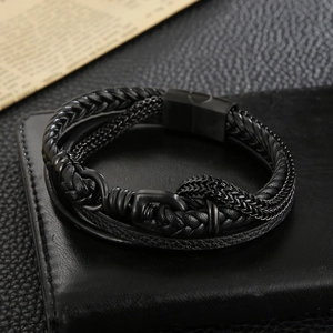 Detail of multi-layer woven black leather men's bracelet with magnetic metal clasp