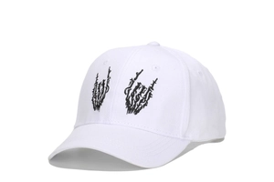 Detailed view of black rock gesture skeleton hand embroidery on a white cotton baseball cap