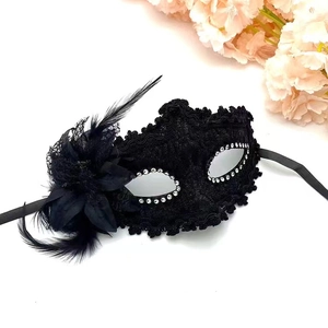 Detail of black lace masquerade mask with shiny rhinestones and elegant soft feathers