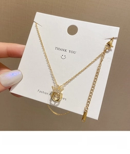 Macro detail of gold crown pendant necklace featuring movable center and zircon stones