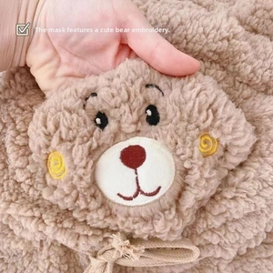 Vue détaillée de la broderie d'ours mignon sur un ensemble bonnet écharpe en peluche